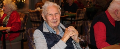 Bewoner geniet bij De Horst met glaasje wijn.